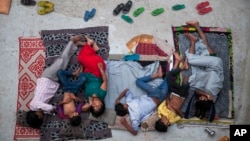 An Indian family sleeps on the roof of a house to beat the heat in New Delhi, India, May 29, 2015. (AP Photo/Tsering Topgyal)
