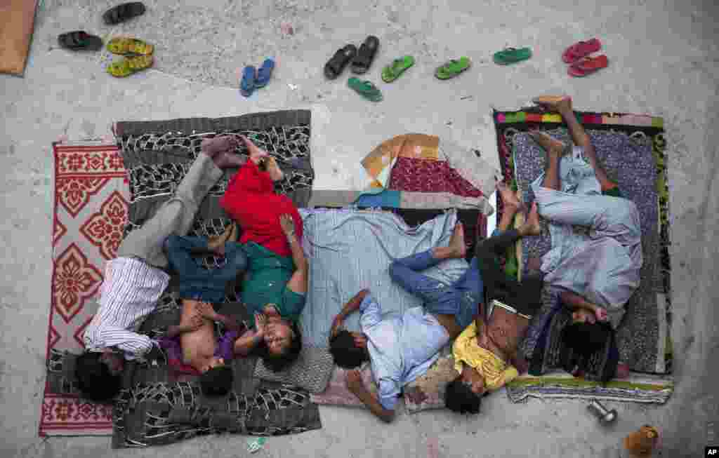 A family sleeps on the roof of a house to beat the heat in New Delhi, India. In neighborhoods with irregular electric supply and sometimes to escape the heat that gets trapped in concrete houses people often sleep outside at night.