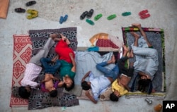 FILE - An Indian family sleeps on the roof of a house to beat the heat in New Delhi, India, May 29, 2015.