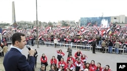 Syria's President Bashar al-Assad addresses his supporters during a surprise appearance at a rally in Umayyad Square in Damascus, January 11, 2012.