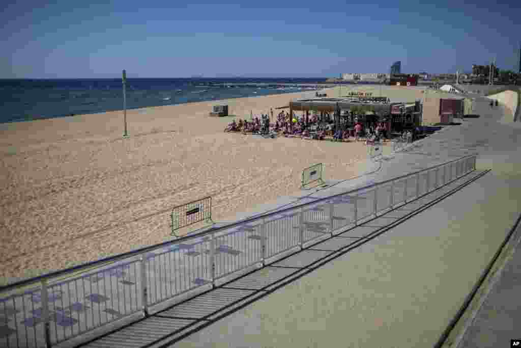 People gather on a terrace in a beach where access is not allowed in that time slot, in Barcelona, Spain.