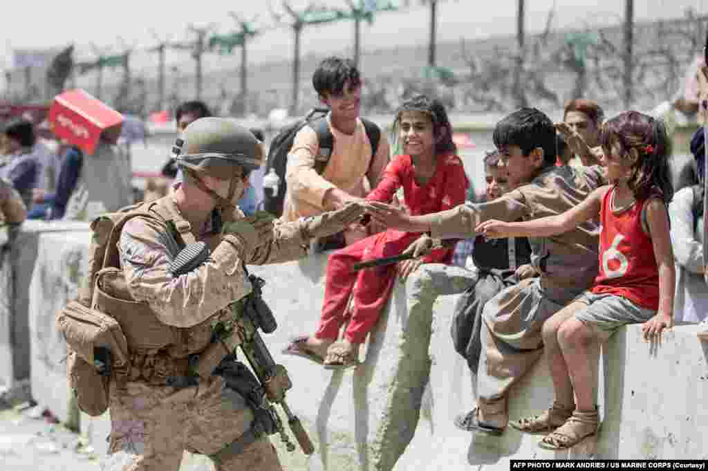 امریکی سینٹرل کمانڈ کی جانب سے جاری اس تصویر میں کم سن افغان بچوں کو امریکی اہلکار کے ساتھ دیکھا جا سکتا ہے۔