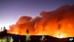 FILE - Seen in a long camera exposure, the Caldor Fire burns on Aug. 29, 2021, in Eldorado National Forest, Calif.