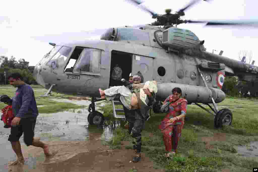 Foto bertanggal 6 September 2014 dirilis oleh Kantor Penerangan Pemerintah India menunjukkan penduduk yang terkena banjir diselamatkan oleh helikopter Angkatan Udara India, di negara bagian Jammu dan Kashmir.