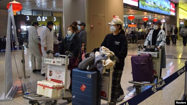 中国黑龙江省会哈尔滨机场的旅客为防疫戴着口罩。(2020年4月11日)