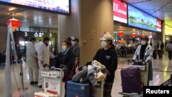 中国黑龙江省会哈尔滨机场的旅客为防疫戴着口罩。（2020年4月11日）
