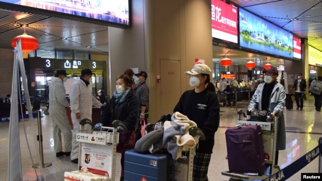 中国黑龙江省会哈尔滨机场的旅客为防疫戴着口罩。(2020年4月11日)