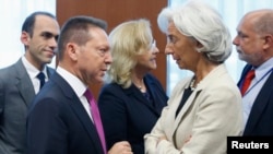 Greece's Finance Minister Yannis Stournaras talks to IMF Managing Director Christine Lagarde (R) during a eurozone finance ministers meeting in Brussels July 8, 2013.