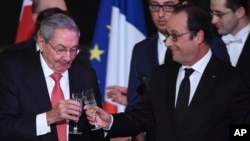Cuban President Raul Castro, left, and French President Francois Hollande raise a glass during a state diner at the Elysee Presidential Palace in Paris, France, Feb. 1, 2016. 