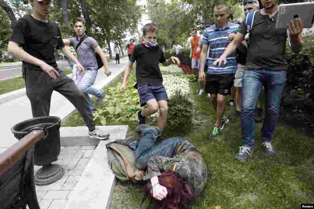 Youths kick a gay rights activist during a protest against a proposed new law termed by the State Duma, the lower house of Parliament, as &quot;against advocating the rejection of traditional family values&quot; in central Moscow, Russia. 