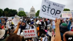 Protesters hold anti-war placards in front of the National Diet building during a rally in Tokyo, Aug. 30, 2015. Thousands of Japanese protested outside the parliament a set of security bills designed to expand the role the country's military.
