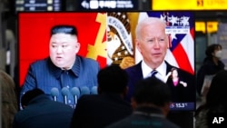 FILE - Commuters watch a TV showing file images of North Korean leader Kim Jong Un and U.S. President Joe Biden during a news program at the Suseo Railway Station in Seoul, South Korea, March 26, 2021.