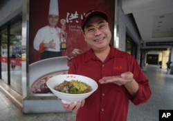 Chef Hung shows pineapple beef noodle outside of his restaurant in Taipei, Taiwan, Wednesday, March 10, 2021. (AP Photo/Chiang Ying-ying)