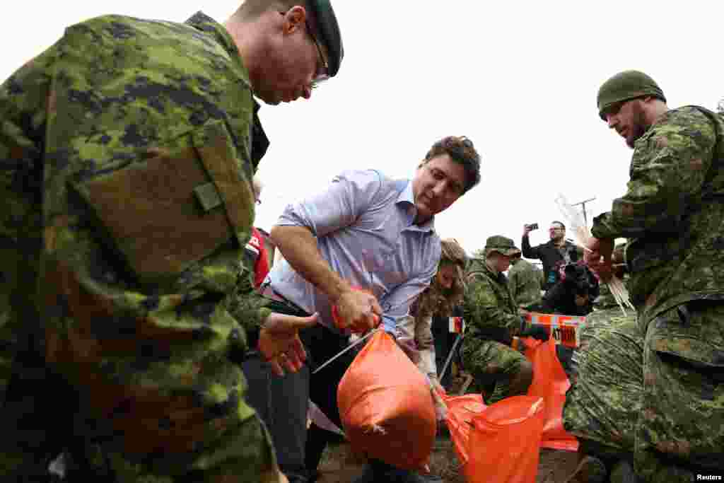 នាយករដ្ឋមន្ត្រីកាណាដា លោក Justin Trudeau កំពុងជួយរៀបចំបាវខ្សាច់នៅជិតតំបន់ដែលប៉ះពាល់ដោយទឹកជំនន់ នៅទីក្រុង Gatineau ក្បែរទីក្រុង Quebec ប្រទេសកាណាដា។