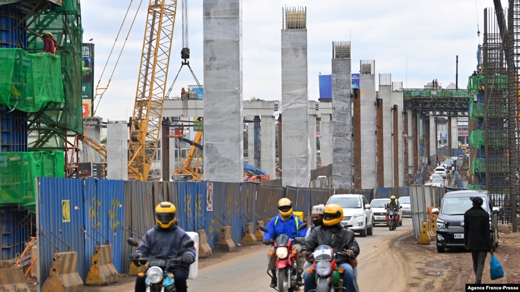 资料照片：驾车者在蒙巴萨公路上行驶，旁边是正在施工的内罗毕高速公路，由中国路桥公司承建。(2021年7月12日)(photo:VOA)