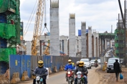FILE - Motorists drive on Mombasa road, next to the ongoing construction site of the Nairobi Expressway, undertaken by the Chinese contractor China Road and Bridge Corporation (CRBC), in Nairobi, Kenya, July 12, 2021.