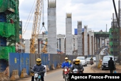 FILE - Motorists drive on Mombasa road, next to the ongoing construction site of the Nairobi Expressway, undertaken by the Chinese contractor China Road and Bridge Corporation (CRBC), in Nairobi, Kenya, July 12, 2021.