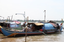 A man sits on a fishing boat on the Mekong River in Sangkat Chroy Changva, Khan Chroy Changva, Phnom Penh, June 9, 2021. (Vicheika Kann/VOA)