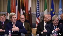 Sekretè Deta ameriken an, John Kerry (agoch) ak Minis Afè Etranjè italyen an, Paolo Gentiloni (devan, adwat) pandan yo tap patisipe nan yon konferans entènasyonal sou Libi nan Depatman Afè Etranjè a nan vil Wòm, dimanch 13 desanm 2015 la.