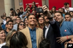 Spanish Prime Minister and Socialist Party candidate Pedro Sanchez, center, smiles for a photo during an election campaign event in Toledo, central Spain, April 26, 2019. What undecided voters do in this tight race will shape the fortunes of the two political blocs that loosely took shape during campaigning that ended Friday.