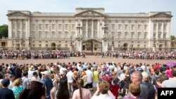 Crowds of tourists gather on the steps of the Queen Victoria Memorial Statue outside Buckingham Palace in central London on July 22, 2013. 