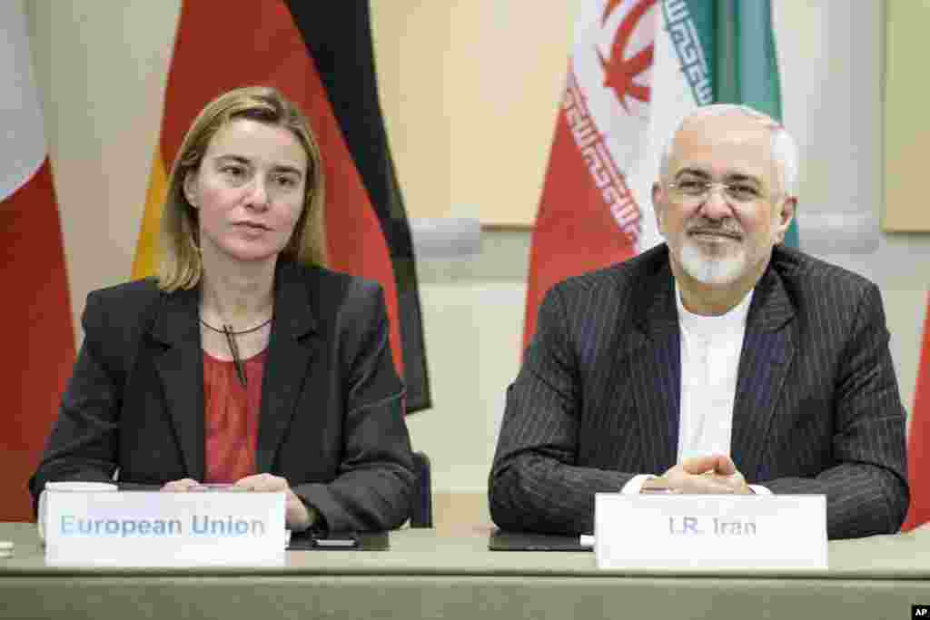 محمد جواد ظريف وزير امور خارجه جمهوری اسلامی ايران (راست)، و فدريکا موگرينی مسئول سياست خارجی اتحاديه اروپا به همراه مقامات فرانسوی، چينی، اتحاديه اروپا، روسيه، آلمان، بريتانيا و ايالات متحده در سالن هتل بوريواژ در لوزان سوئيس منتظر آغار جلسه در مورد برنامه هسته‌ای ايران هستند. ديپلمات‌ها روز سه شنبه تلاش کردند تا در مورد خطوط اصلی موافقتنامه‌ای بر سر برنامه هسته‌ای تهران به توافق برسند. ۱۱ فروردين ۱۳۹۴ (۳۱ مارس ۲۰۱۵)
