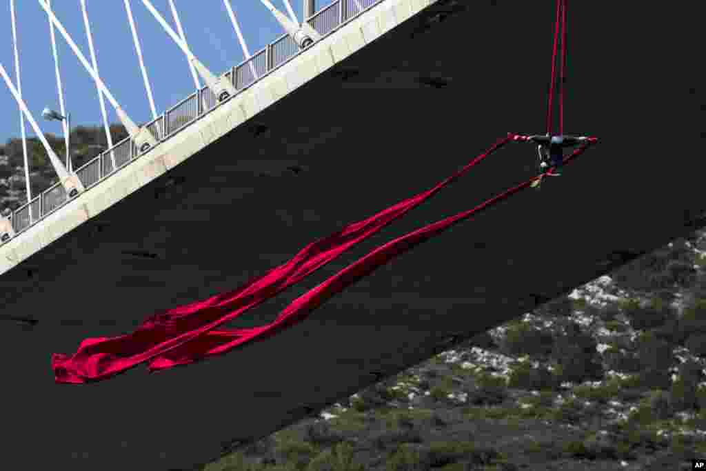 Extreme Aerial dance artist Katerina Soldatou performs on a 34-meter (111 foot) high bridge in the city of Chalkida, about 80 kilometers north of Athens, Greece.