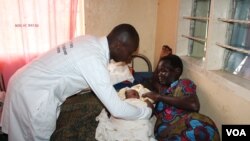 A health worker helps a new mother at Mungula Health Center 3, in Adjumani district, northern Uganda, June 14, 2017. (H. Athumani/VOA)