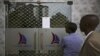 People read a notice from the Central Bank of Kenya taped to the closed entrance of a Chase Bank branch, after the bank was put under receivership, in Nairobi, April 8, 2016. 