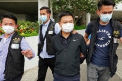 Ryan Law (second from right), Apple Daily's chief editor, is arrested by police officers on June 17, 2021. AP