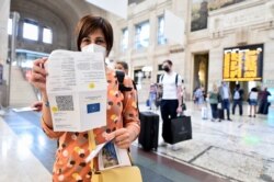 Seorang perempuan menunjukkan "Green Pass" COVID-19-nya di stasiun kereta di Milan, Italia, 1 September 2021. (REUTERS/Flavio Lo Scalzo)