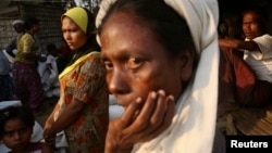 Rohingya people wait to receive their share of food aid from the World Food Program (WFP) at the Thae Chaung camp for internally displaced people in Sittwe, Rakhine state.