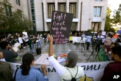 FILE - In this June 20, 2018, photo, protesters demonstrate outside the federal courthouse in Sacramento, Calif., where a judge heard arguments over the U.S. Justice Department's request to block three California laws that extend protections to people in the country illegally. Sacramento is a sanctuary city.