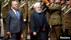 Iraq's President Barham Salih walks with Iranian President Hassan Rouhani during a welcome ceremony at Salam Palace in Baghdad, Iraq, March 11, 2019.