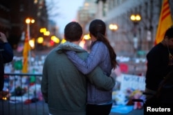 A couple embraces at a memorial on Boylston Street to the bombing victims, April 21, 2013.