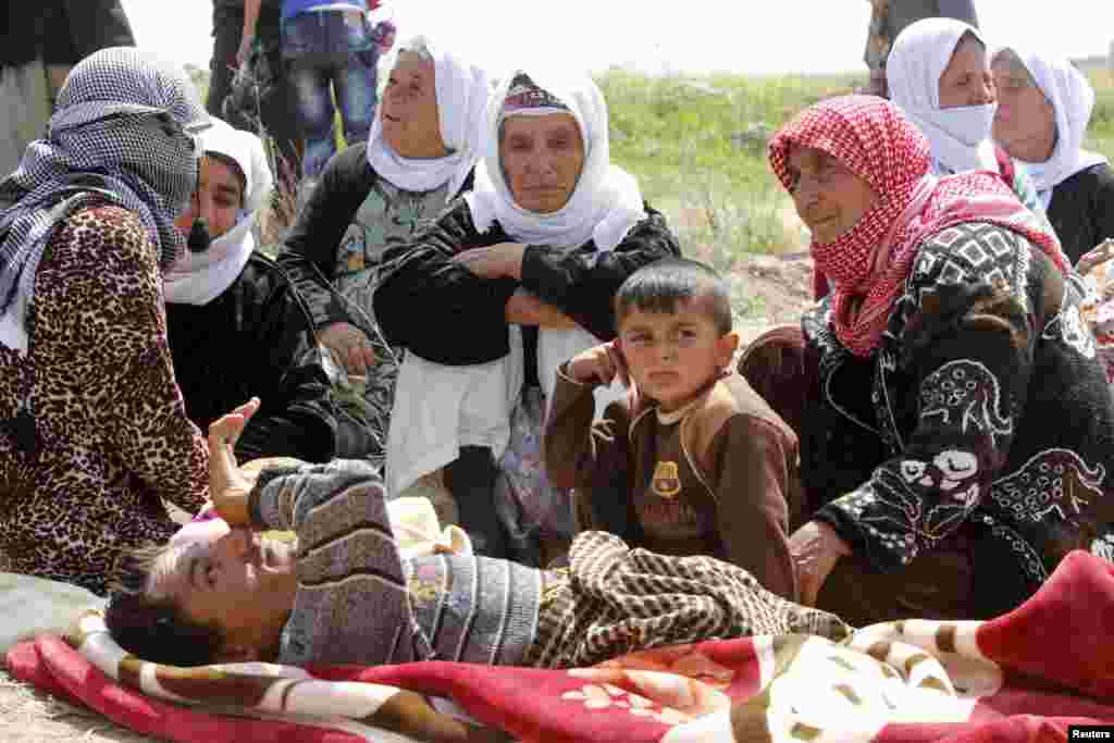 More than 200 members of Yazidi religious community, freed eight months after they were taken captive by Islamic State militants, wait on the edge of Kirkuk, Iraq, for relocation.