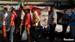 Supporters of deposed Egyptian President Mohamed Morsi stand in a line as volunteers distribute juice ahead of iftar (breaking of fast) during the holy month of Ramadan, as they continue a sit-in around Rabaa Adawiya mosque, east of Cairo, July 17, 2013.