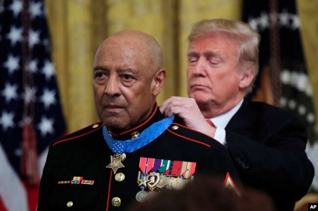 FILE - President Donald Trump presents the Medal of Honor to U.S. Marine Corps retired Sgt. Maj. John Canley, during an East Room ceremony at the White House in Washington, Oct. 17, 2018.