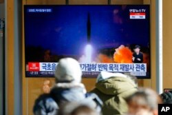 Orang-orang menonton layar TV yang menayangkan program berita yang melaporkan peluncuran rudal Korea Utara di stasiun kereta api di Seoul, Korea Selatan, 12 Januari 2022. (Foto: AP)