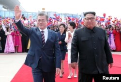 문재인 한국 대통령 내외와 김정은 북한 국무위원장 내외가 18일 평양 순안공항에서 열린 공식 환영식에서 평양 시민들의 환영을 받으며 이동하고 있다. 평양사진공동취재단.