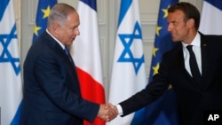 French President Emmanuel Macron and Israel's Prime Minister Benjamin Netanyahu shake hands as they attend a joint press conference at the Elysee Palace in Paris, June 5, 2018.