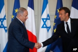 French President Emmanuel Macron and Israel's Prime Minister Benjamin Netanyahu shake hands as they attend a joint press conference at the Elysee Palace in Paris, June 5, 2018.