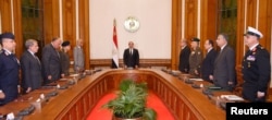 FILE - Egyptian President Abdel Fattah el-Sissi, center, stands and observes a minute of silence for the victims of two separate church attacks during Palm Sunday prayers, April 9, 2017.