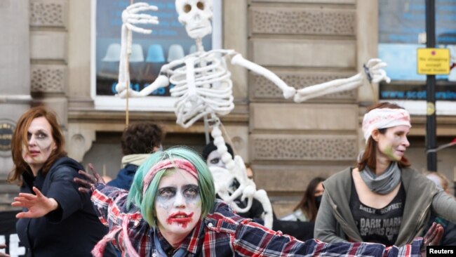 Protesters wearing costumes attend a demonstration in support of victims of oil exploration and against fossil fuel investments in Africa during the UN Climate Change Conference (COP26), in Glasgow, Scotland, Nov. 7, 2021.