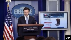 White House press secretary Josh Earnest uses a graphic to discuss the Trans-Pacific Partnership during the daily briefing at the White House in Washington, Oct. 13, 2015.