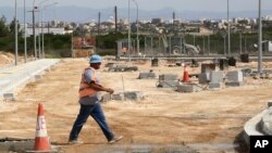 A worker passes inside the construction of a crossing point that will link ethnically divided Cyprus' breakaway Turkish Cypriot north and internationally recognized south in Dherynia, April 27, 2017. 