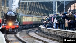 FILE - People watch from a railway platform as the Flying Scotsman steam engine prepares to leave Kings Cross station in London, February 25, 2016. (REUTERS/Paul Hackett/File)