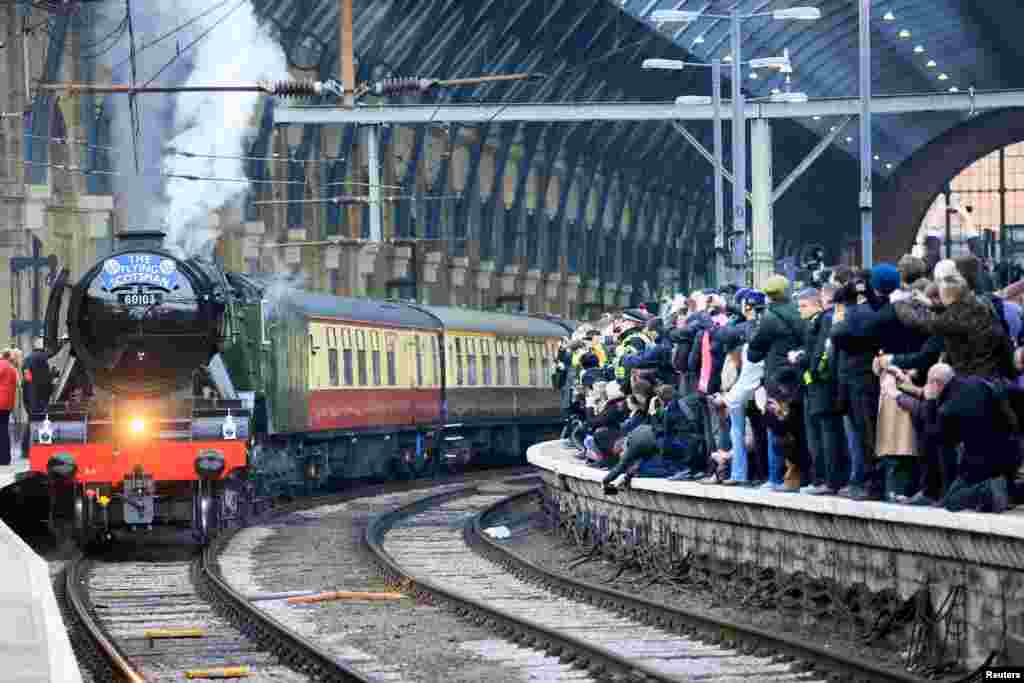 People watch the Flying Scotsman steam engine preparing to leave Kings Cross station in London.