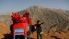 An Afghan boy stands with a donkey loaded with election material, to be transported to polling stations which are not accessible by road, in Shutul, Panjshir province, Afghanistan.