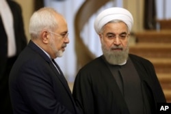 FILE - Iranian President Hassan Rouhani, right, talks with his Foreign Minister Mohammad Javad Zarif in Tehran, Iran, Nov. 24, 2015.